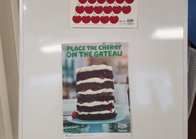 A Macmillan Cancer Support poster and Place the Cherry on the Cake game at St Winifreds