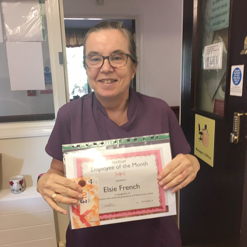 Employee of the month Elsie French holding up a certificate and shopping vouchers