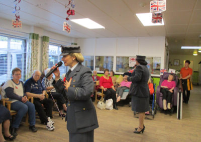 Residents listening to The Good Time Sweethearts singing in the lounge area