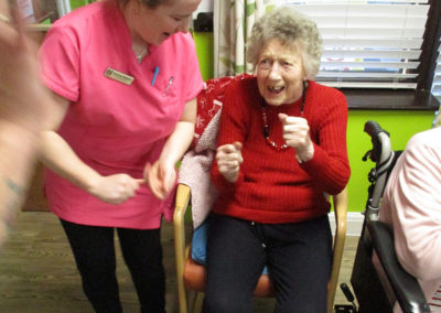 St Winifreds resident dancing in her chair and singing to The Good Time Sweethearts