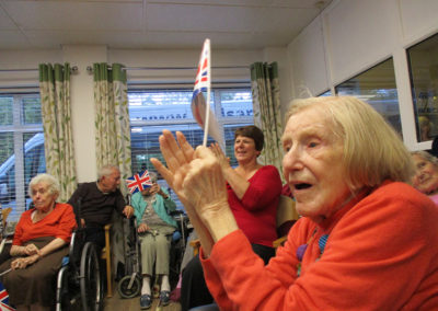 A close up of a St Winifreds resident clapping as she enjoys music duo The Good Time Sweethearts