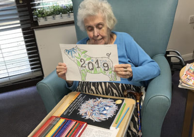 A lady resident holding her Year of the Pig colouring picture