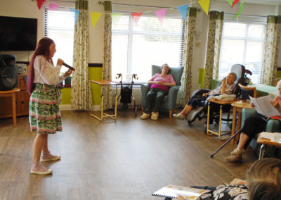 Care Assistant Jess at St Winifreds leading a singalong session