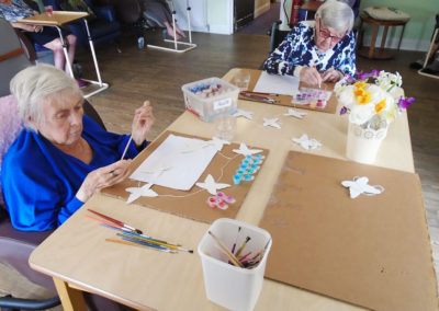 Lady residents making butterfly bunting at St Winifreds Residential Care Home