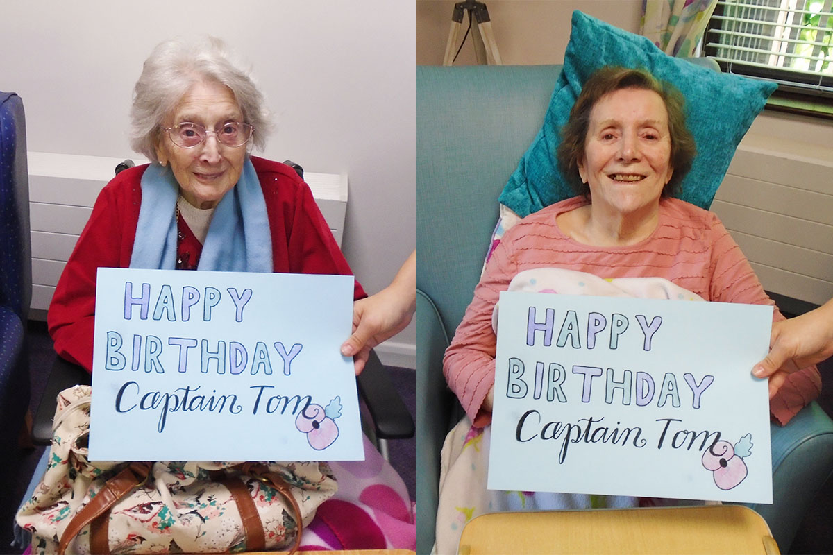 Two St Winifreds Residential Care Home ladies with a Happy Birthday Captain Tom sign